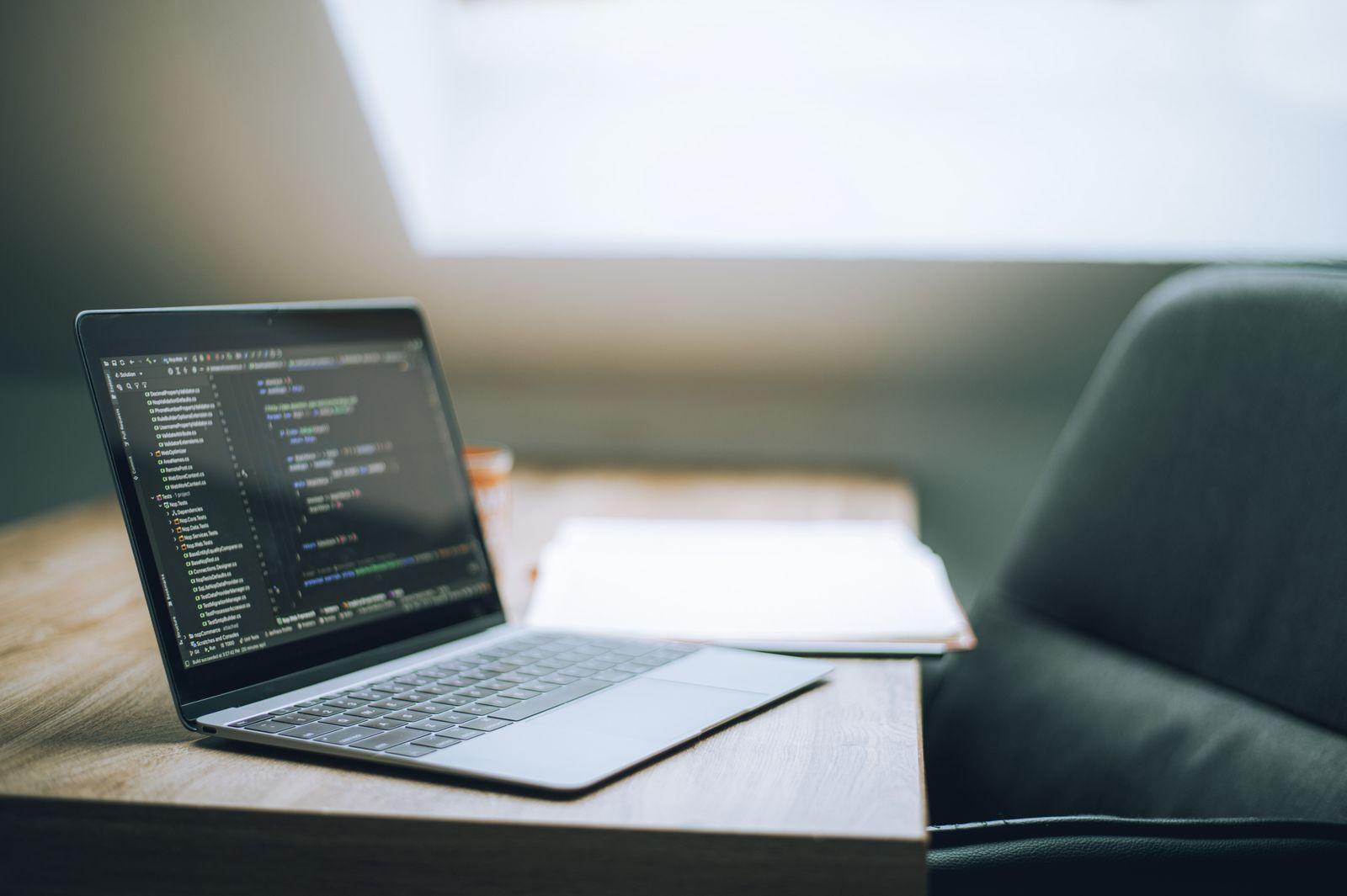 Espace de travail avec ordinateur portable affichant du code de site web